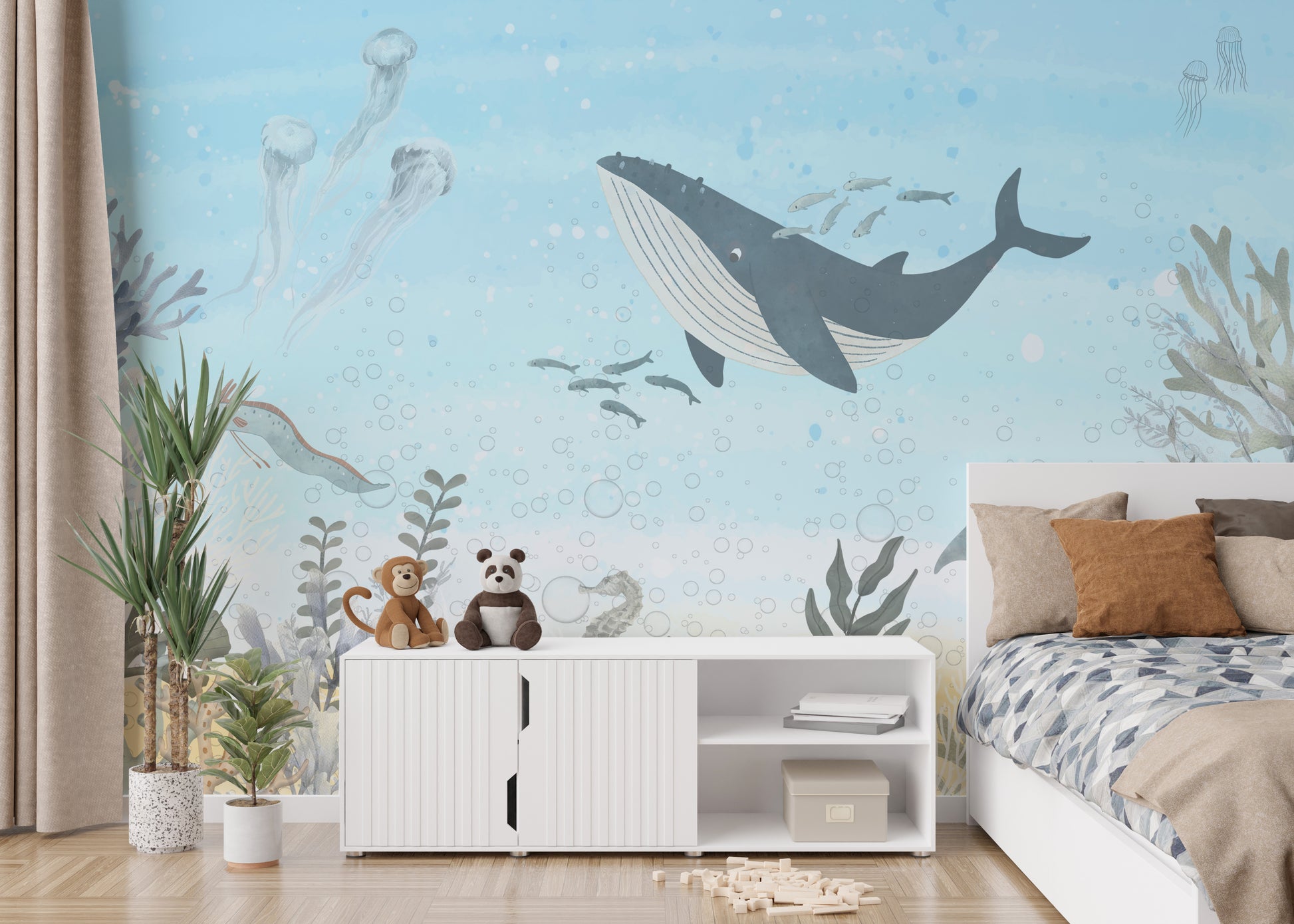 Oceanic Harmony wallpaper mural with a grey whale, jellyfish and seaweed in pale blue in a kids bedroom with a bed and plush toys