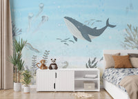 Oceanic Harmony wallpaper mural with a grey whale, jellyfish and seaweed in pale blue in a kids bedroom with a bed and plush toys