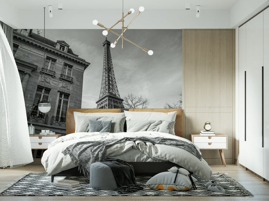 Old building next to Eiffel tower black and white wall mural above a tan leather bed in a modern bedroom