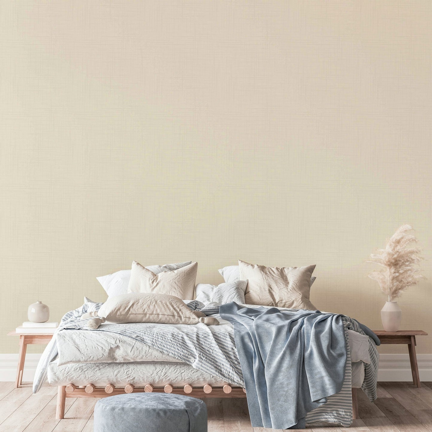 Old Canvas Cannoli Cream wallpaper in beige behind a wood platform bed with blue and cream bedding and pampas grass