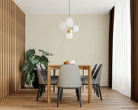 Old Canvas Cannoli Cream wallpaper in cream behind a wood dining table with grey chairs, monstera and globe chandelier