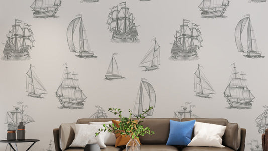 Old World Sailing wallpaper mural of grey sketched sailing ships behind a brown sofa with blue cushions in a living room