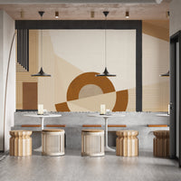 Geometric Modern Art wallpaper mural with terracotta circle behind cafe tables and woven rattan stools