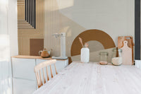 Geometric Modern Art wallpaper mural with tan stripes and terracotta arch in a sunlit kitchen with jars
