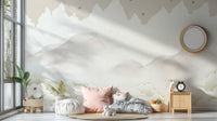 Serene Mountain Peaks wallpaper mural of soft clouds and stars in a nursery with floor cushions, pink pillow and toy unicorn