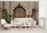 Ornate Entryway wallpaper mural of an arched wooden door behind a cream sofa, armchair and white coffee table