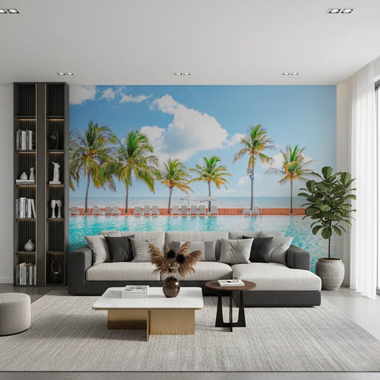 Palm Pool Escape wall mural of palm trees by a turquoise resort pool behind a grey sofa and black bookshelf