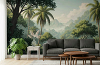Palm Vista wallpaper mural of palms and misty peaks behind a charcoal sofa and monstera plant in a living room