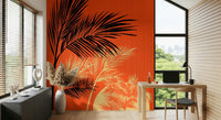 Palms at Sunset wallpaper mural with black and cream palms on orange behind a wood desk in a home office