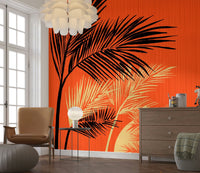 Palms at Sunset wallpaper mural of bold palm fronds on orange beside a tan armchair and wood dresser
