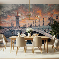 Parisian Bridge Sunset wallpaper mural with the Paris bridge behind a wood dining table and beige chairs
