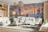 Parisian Bridge Sunset wallpaper mural showing the Paris bridge and fiery sky over a white sofa in a living room