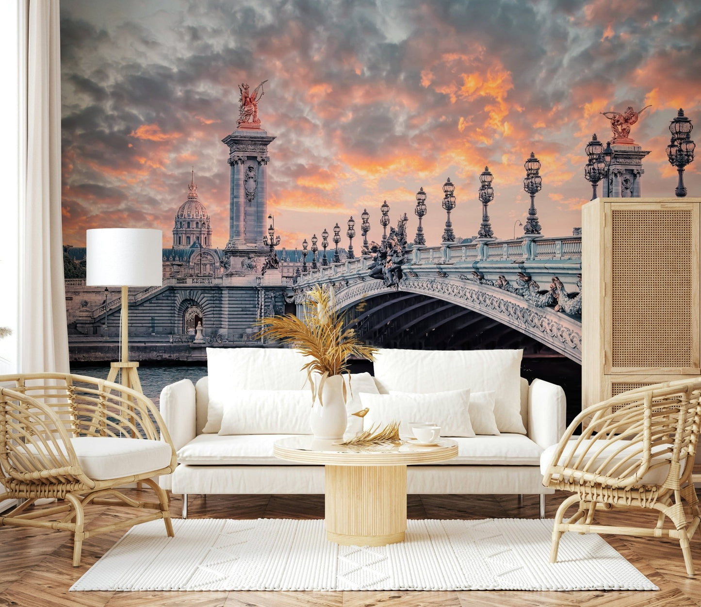 Parisian Bridge Sunset wallpaper mural of the Paris bridge behind a white sofa framed by two rattan armchairs