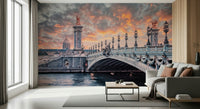 Parisian Bridge Sunset wallpaper mural of the Pont Alexandre III over the Seine beside a gray sofa in a living room