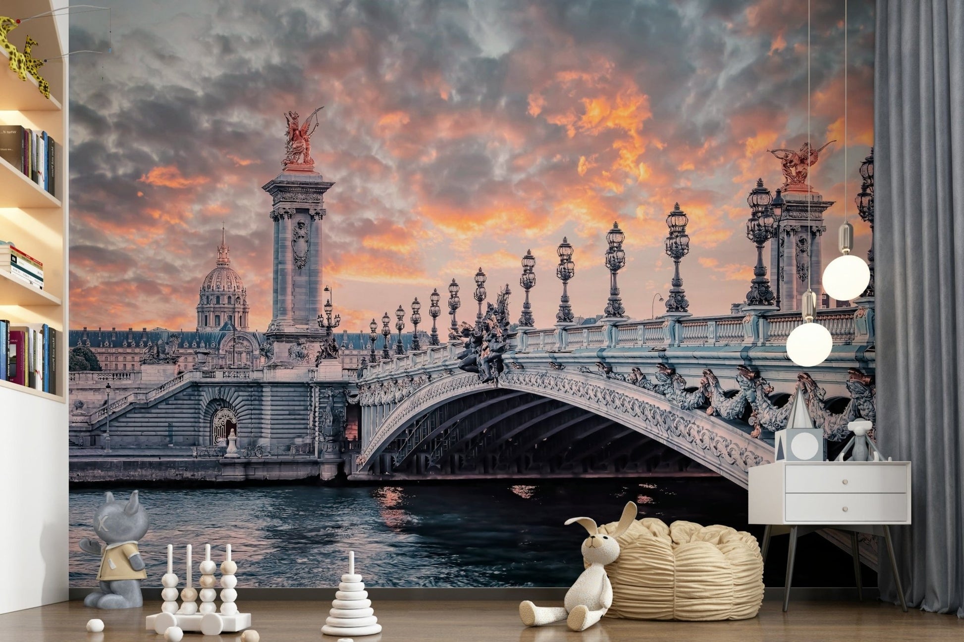 Parisian Bridge Sunset wallpaper mural showing the Paris bridge in a kids room with a white dresser and soft toys