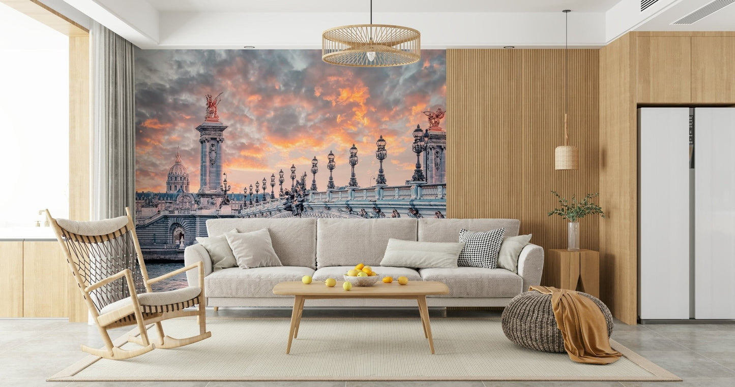 Parisian Bridge Sunset wallpaper mural of the Paris bridge at dusk behind a gray sofa and wood rocking chair