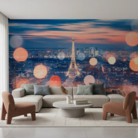 Parisian Lights wallpaper mural of the Eiffel Tower at twilight behind a grey sofa and rust armchairs in a living room
