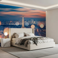 Parisian Lights wallpaper mural of the Eiffel Tower at dusk behind a cream upholstered bed in a modern bedroom