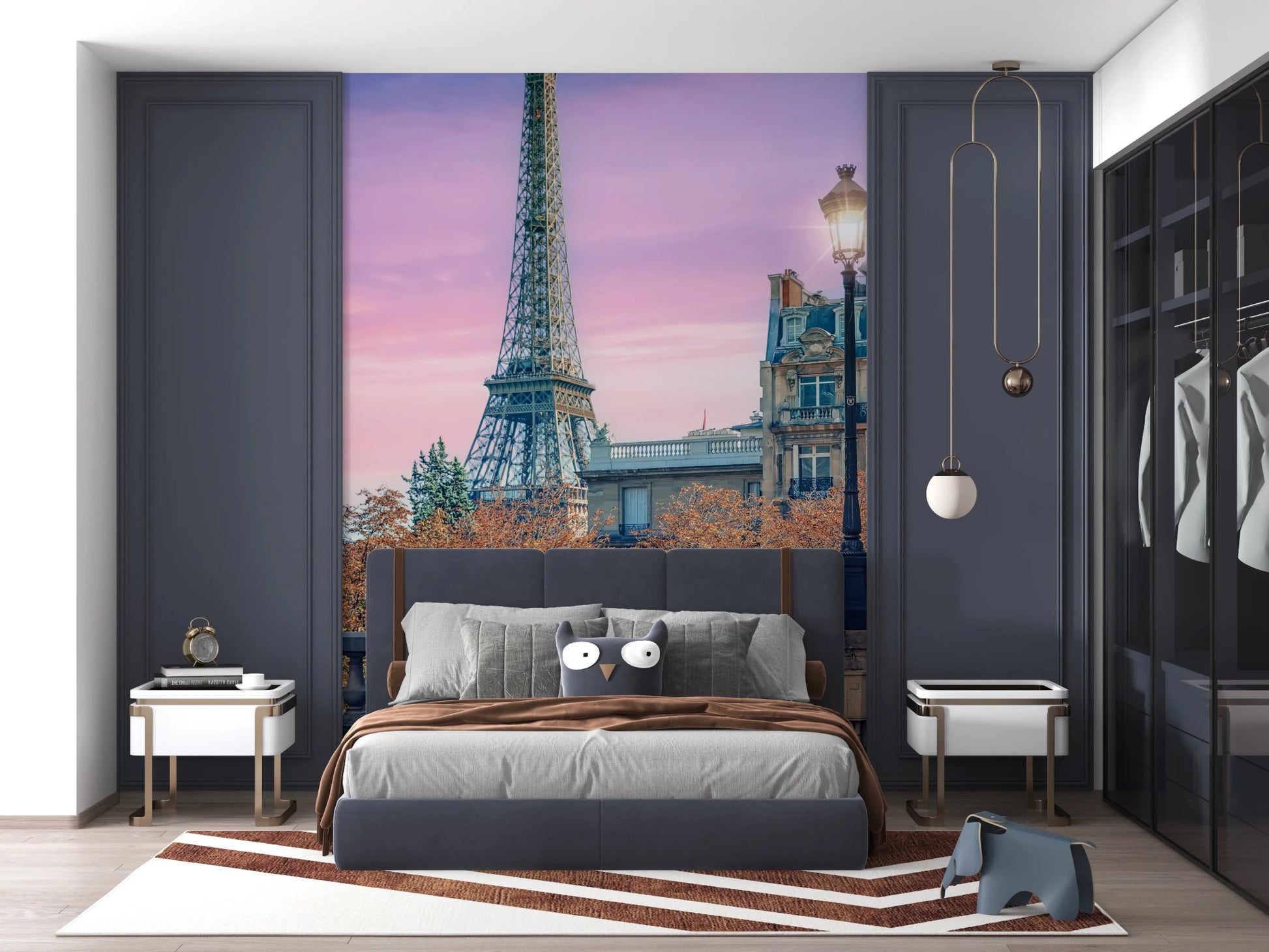 Parisian Twilight wallpaper mural with Eiffel Tower at sunset behind a grey bed framed by navy wardrobes in a bedroom