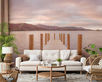 Piering into Nature's Heart wallpaper mural of a serene lake pier behind a cream sofa and palm plant in a living room