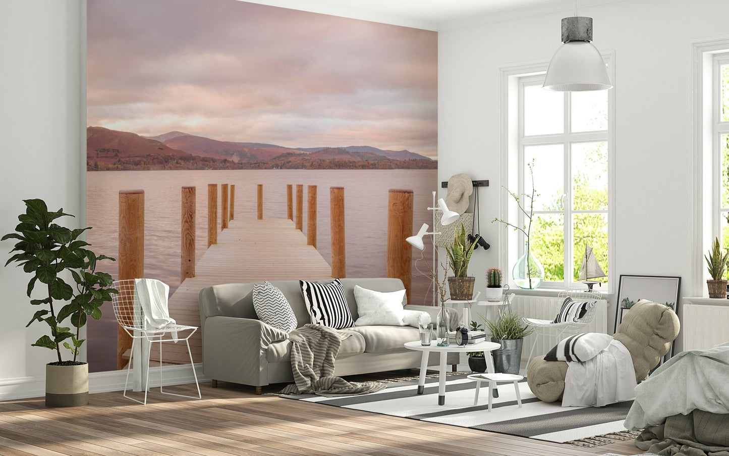 Piering into Nature's Heart wallpaper mural of a wooden pier on a pink lake behind a grey sofa in a bright living room