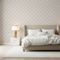 Pink Petal Lattice wallpaper behind a beige upholstered bed with white bedding and a gold table lamp