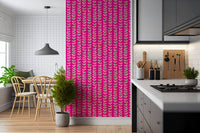 Fuchsia pink wallpaper featuring outlined retro leaf clusters climbing in neat vertical rows.