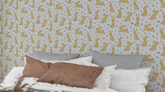 Bunnies and Rabbits Golden Gray wallpaper over a bed with gray pillows and brown cushion in a bedroom
