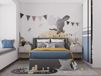 Playful Bunny Car Ride Kids wallpaper mural with bunting behind a grey bed with blue and mustard bedding