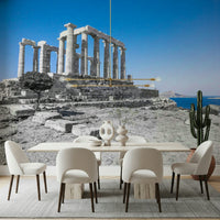 The wallpaper highlights the weathered marble pillars of the Poseidon Temple rising above rocky terrain.