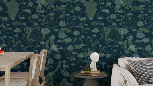 Abyssal Swirl wallpaper mural in dark navy with green fish silhouettes behind a light wood dining table and beige sofa