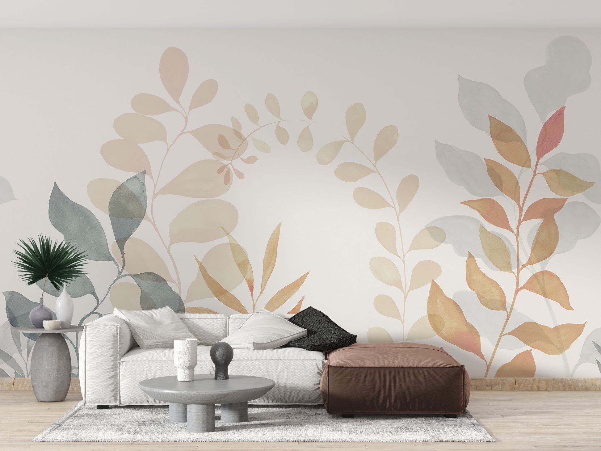 Soft Leaves wallpaper mural with watercolor foliage behind a white sofa and brown leather pouf
