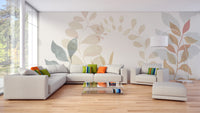 Soft Leaves wallpaper mural in pastel tones behind a beige sectional sofa and arc lamp in a bright living room