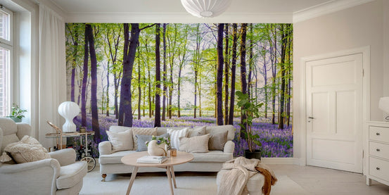 Woodland Bloom Panorama wallpaper mural of a green forest and purple bluebells behind a cream sofa in a bright living room