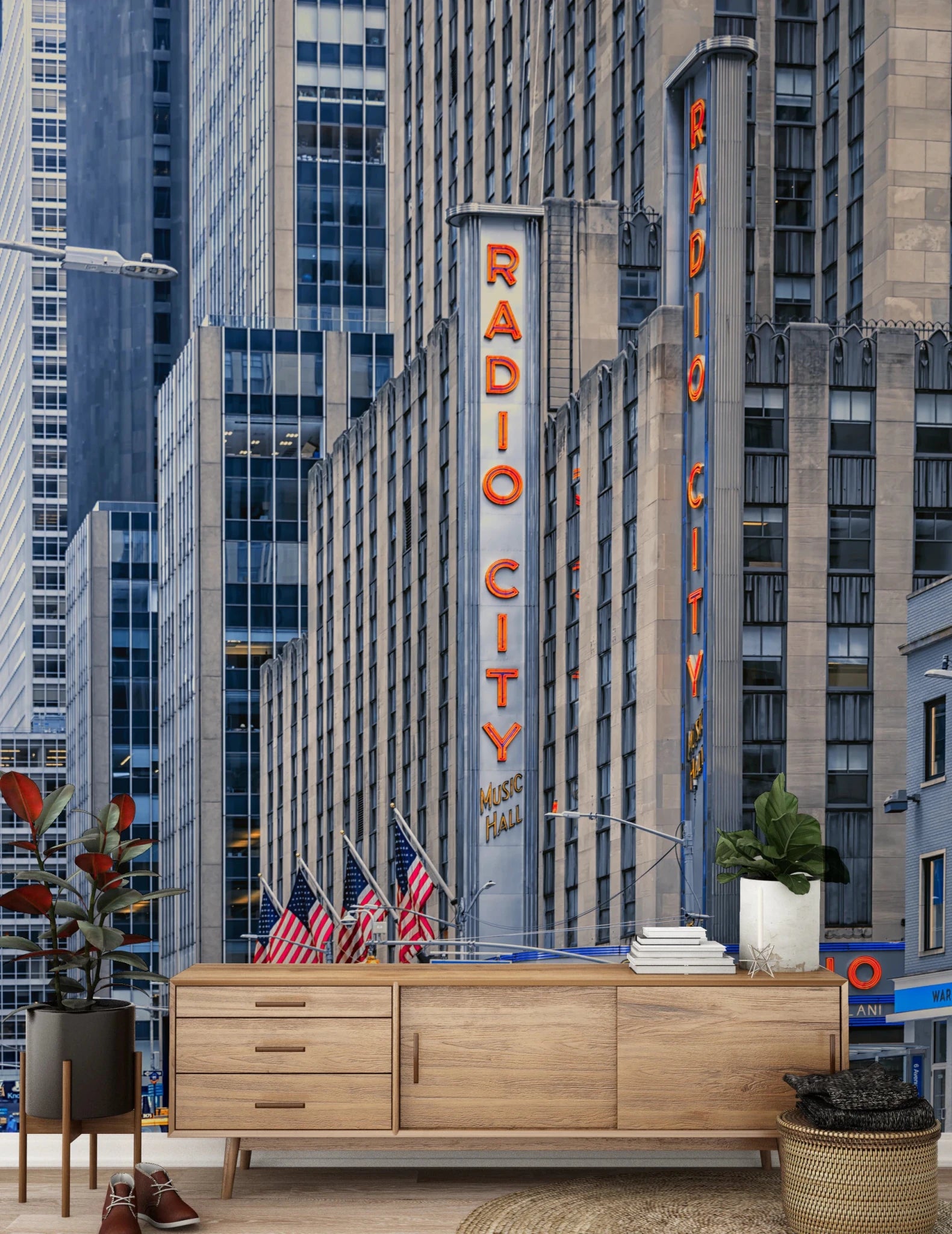 Radio City's Glow wallpaper mural with the red neon sign and flags above a light wood sideboard and rubber plant