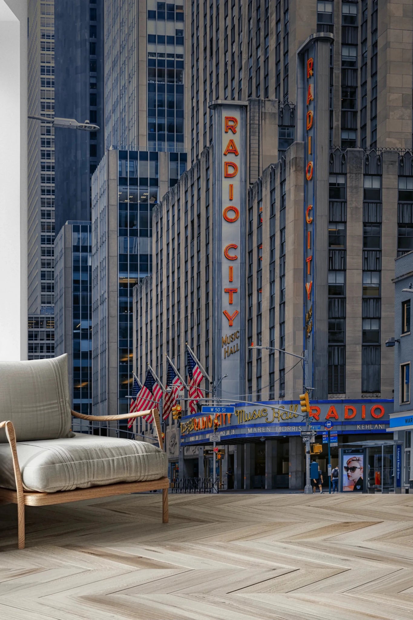 Radio City's Glow wallpaper mural of the red Radio City sign and flags beside a beige wood-arm lounge chair in a living room