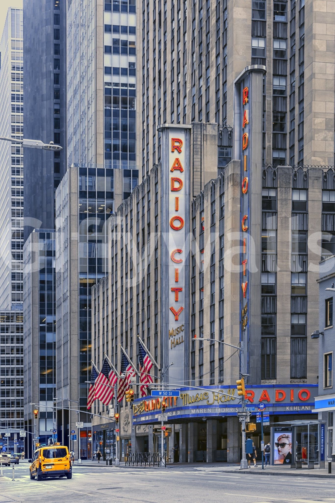 Radio City's Glow wallpaper mural shown full-wall with the red Radio City Music Hall sign, flags and a yellow taxi below