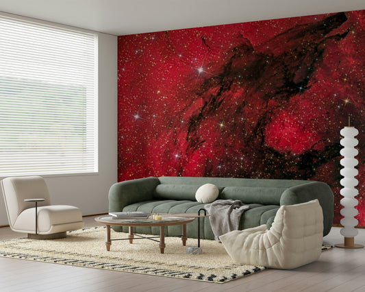 Cosmic Ember wallpaper mural of a red galaxy behind a green sofa and cream armchair in a bright living room
