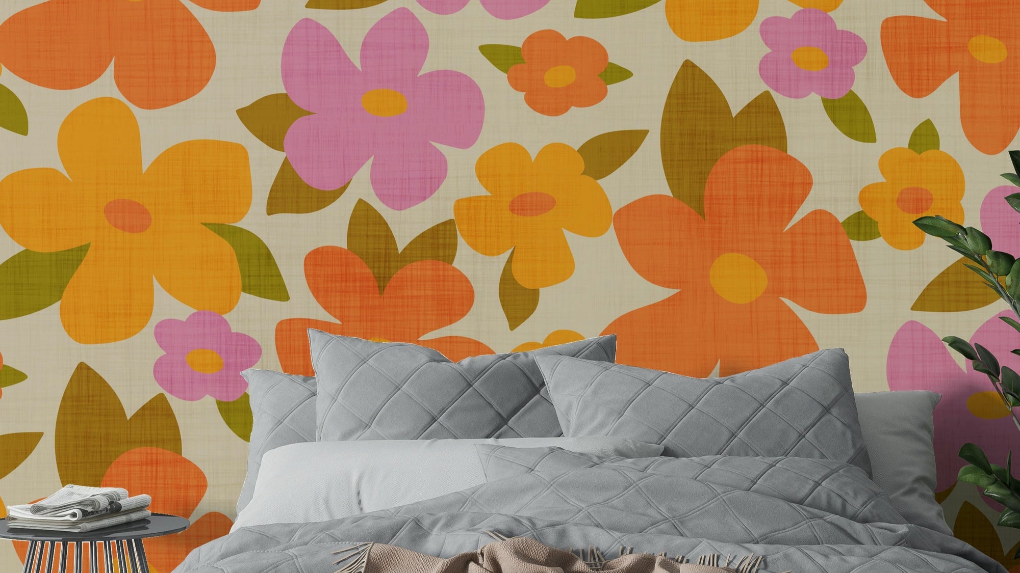 Retro Bright Flowers in Orange Pink Yellow wallpaper above a gray quilted bed in a close-up bedroom view