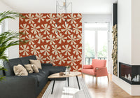Mid-century inspired wallpaper with abstract pinwheel blooms in cream and sunset orange tones.