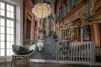 The image shows a small cafe with tables on a cobblestone street.

