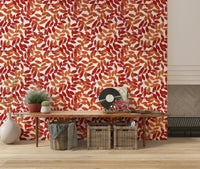 Rustic Leaves wallpaper in red and orange behind a wood console with a record player in an entryway