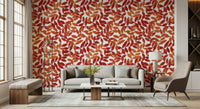 Rustic Leaves wallpaper with red and orange leaves behind a grey sofa and tan armchair in a living room