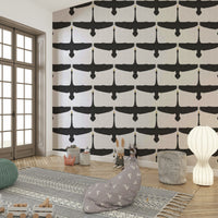 Swan silhouettes soaring across textured gray wallpaper

