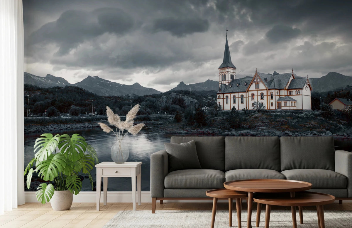 Sacred Shores wallpaper mural of a white church and stormy sky behind a grey sofa and monstera plant in a living room