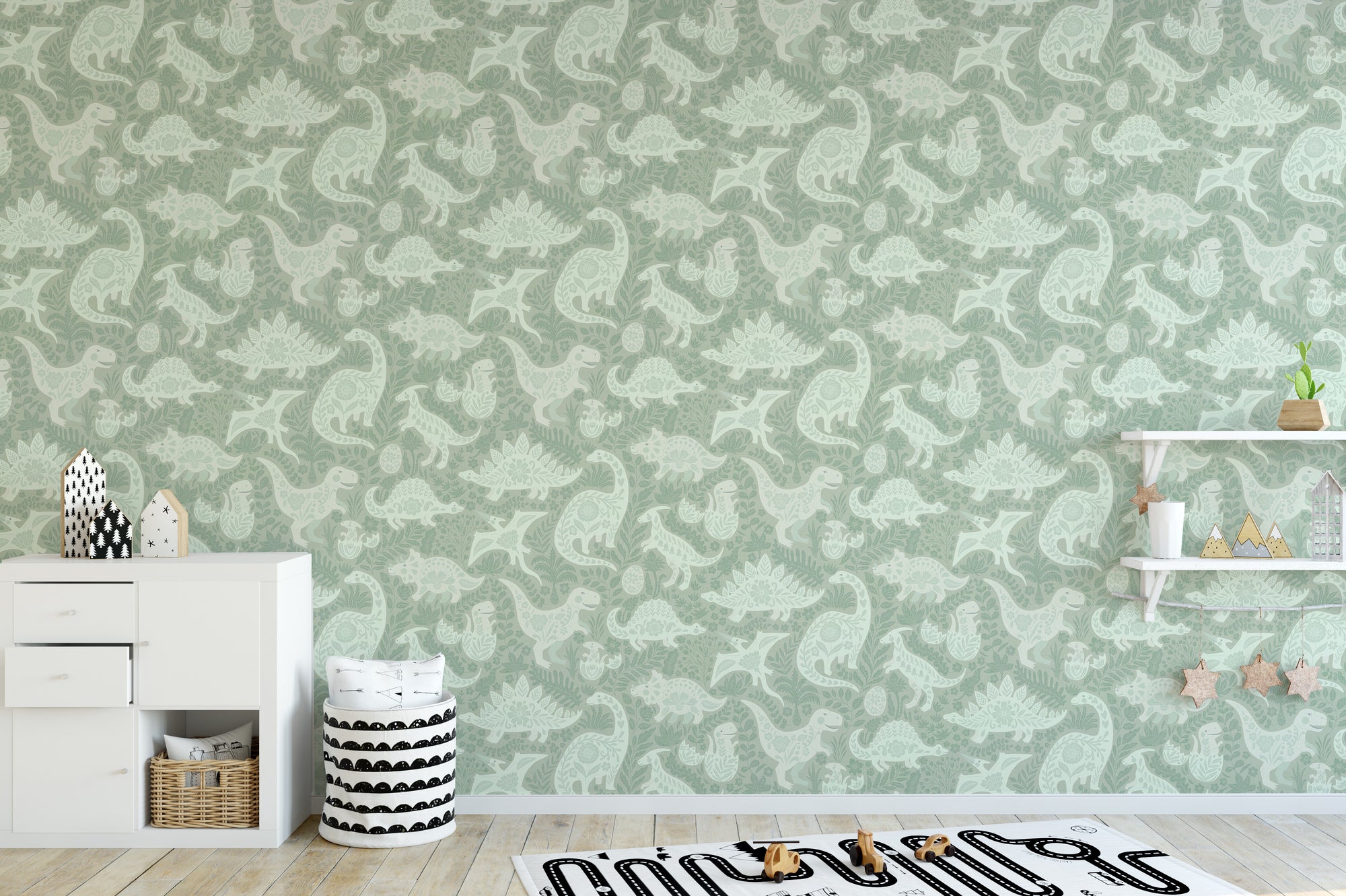 Sage Green Dinosaurs Folk Art wallpaper in a kids room with a white dresser, wall shelves and a road rug