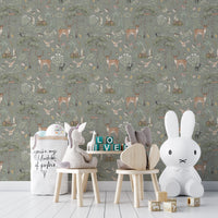 Sage Green Wildlife wallpaper in a nursery with a white Miffy bunny lamp, plush unicorn and wooden stools