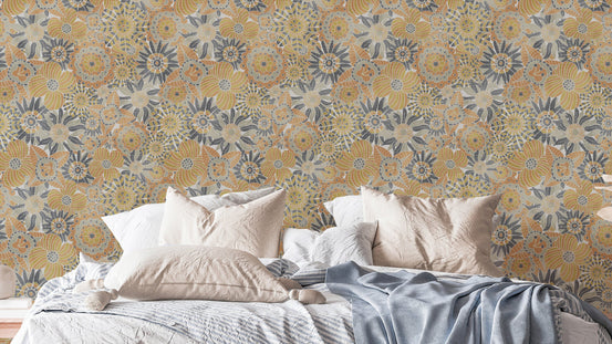 Scandinavian Flowers wallpaper in mustard and blue-grey blooms behind a bed with white and blue bedding