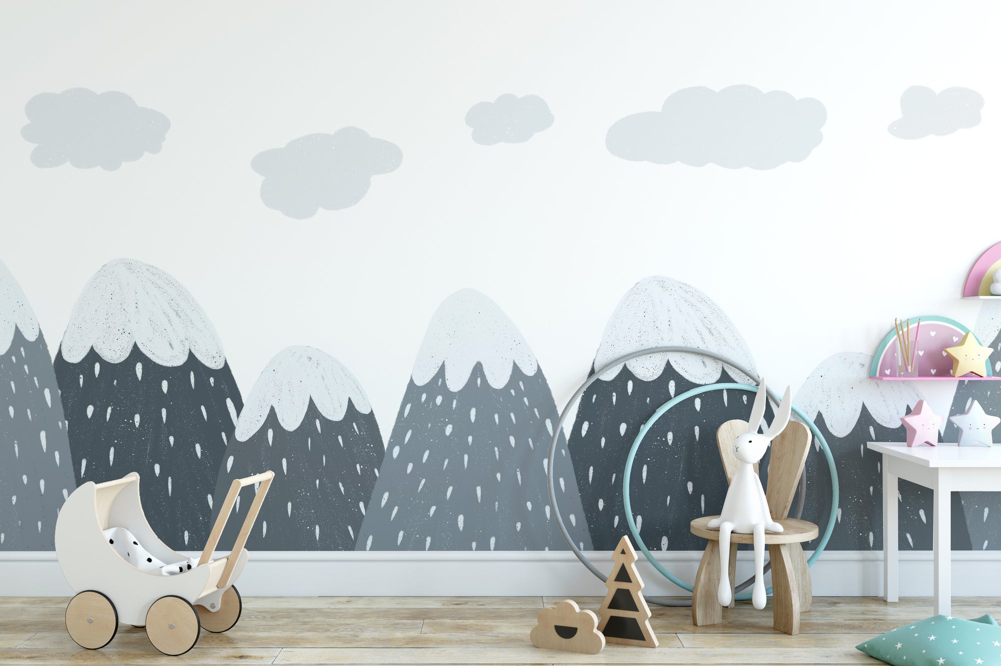 Scandinavian Mountain wallpaper mural with grey snow-capped peaks and clouds in a kids room with wooden toy pram and bunny chair