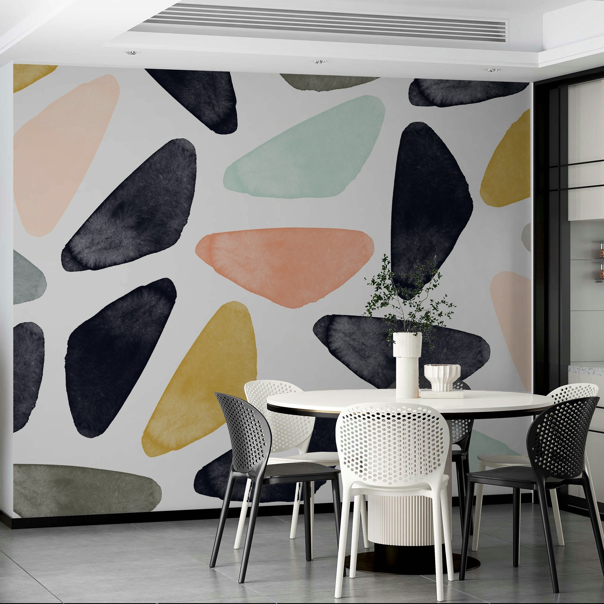 Scandinavian wallpaper mural of navy and peach organic shapes beside a round white table with mesh chairs
